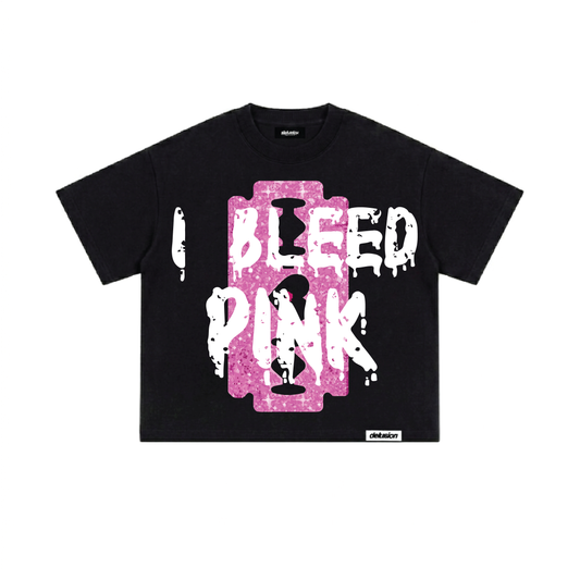 A black short-sleeve t-shirt with a large front graphic reading 'I BLEED PINK' in white dripping letters over a pink rectangular background, shown on a plain white studio background.